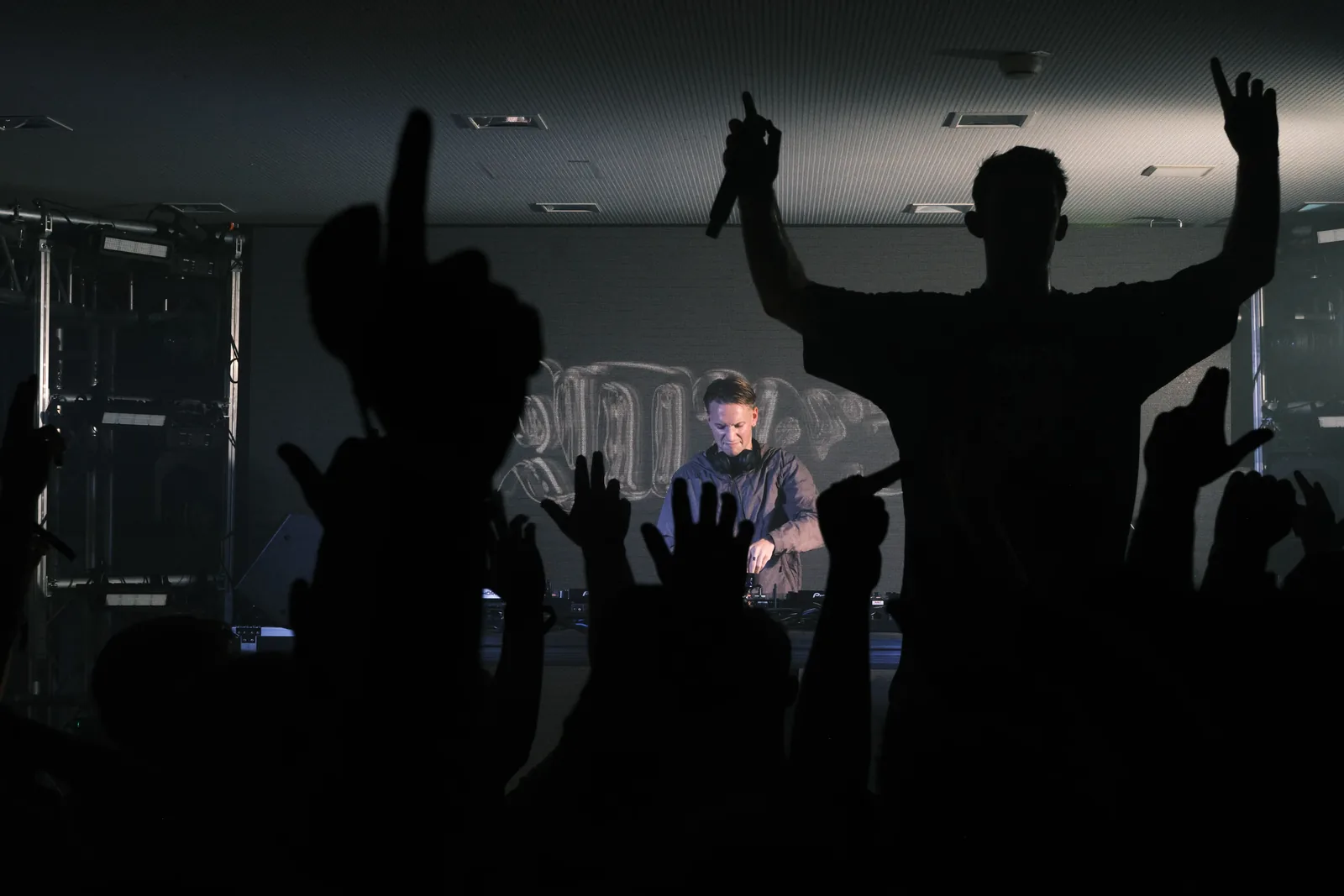 Silhouette des MCs mit Mikrofon vor dem DJ-Pult der DnB-Stage